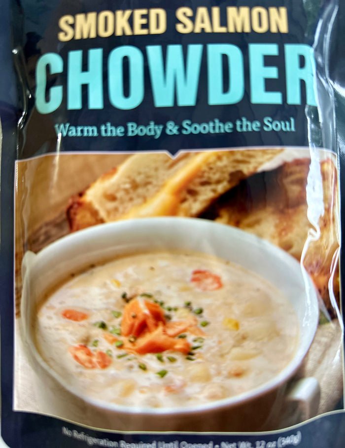 Packaging of smoked salmon chowder with a bowl of soup and crackers on a blue background.