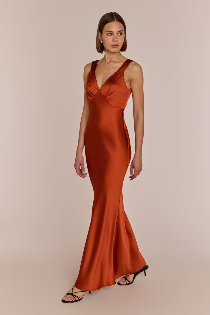 Long burnt orange bridesmaid dress on model with short brown hair