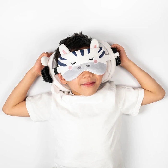 Child wearing Eclectic Relaxeazzz Bali the Zebra plush travel pillow and matching eye mask for comfortable rest