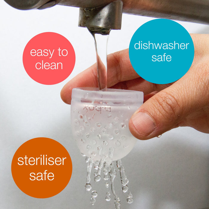 Eclectic B.Box silicone fresh food feeder pouch being rinsed under a tap, highlighting easy cleaning and safety.