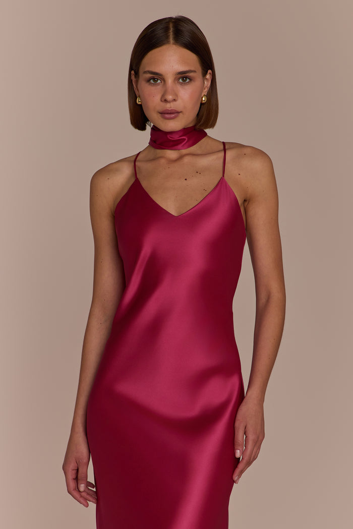 Woman wearing a pink satin dress against a beige background