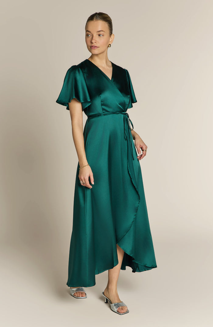 Woman wearing a green dress with a plain background