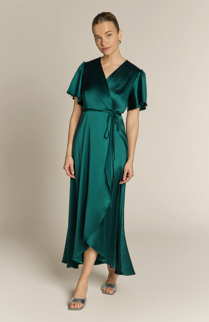 Woman wearing a green dress against a beige background