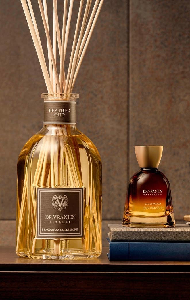 Eclectic Dr Vranjes Leather Oud diffuser bottle with reeds and matching perfume bottle on a wooden surface