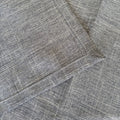 Eclectic ash grey linen-look polyester table runner with a detailed view of the woven fabric texture and stitched hem.