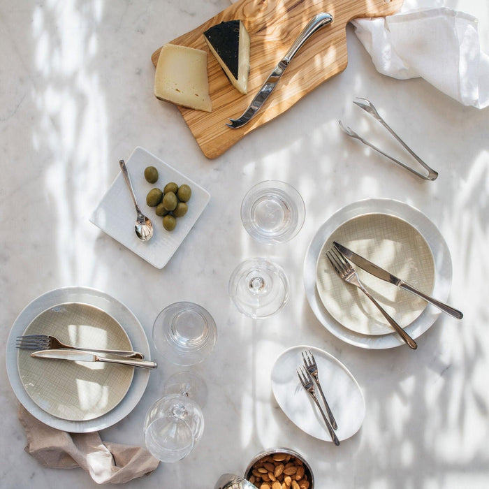 Eclectic Sambonet Living stainless steel ice tongs on a marble table setting with plates and cutlery