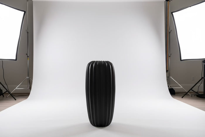 Eclectic 50 cm tall matte black fibrestone vase with a vertical fluted design in a professional studio setting.