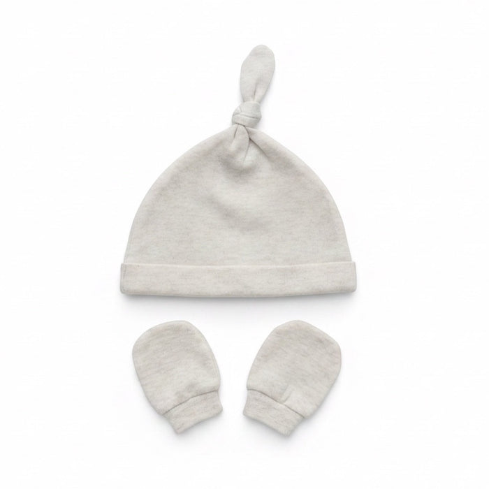 Eclectic newborn knotted hat and matching mittens set in soft neutral cotton for baby comfort and scratch protection.