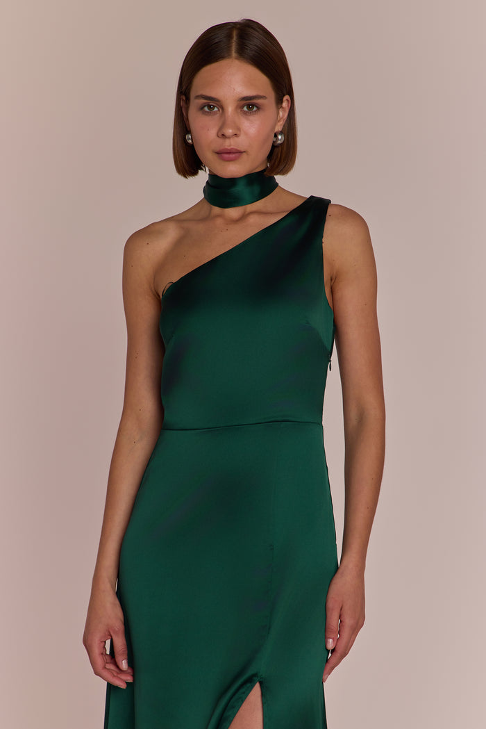 Woman wearing a green one-shoulder dress against a beige background
