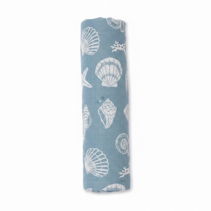 Eclectic Seaside Shells cotton muslin swaddle in seafoam green with white shell print, rolled for display.