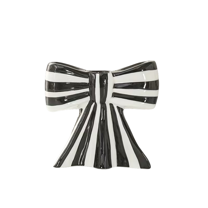 Eclectic black and white striped ceramic bow-shaped taper candle holder with a smooth glazed finish.