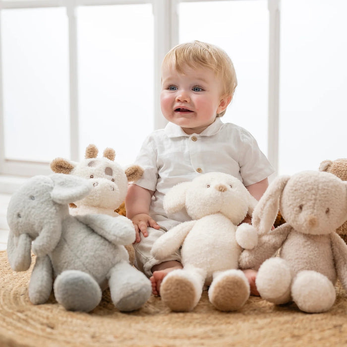 Eclectic Nattou grey elephant plush toy sitting on a rug next to a baby and other stuffed animal friends